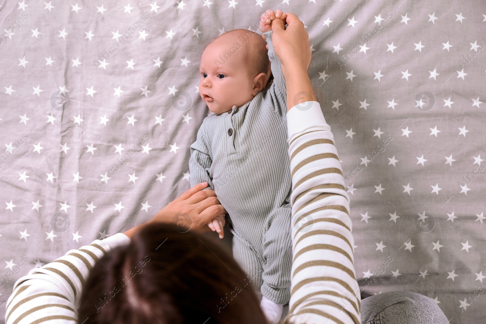 Photo of Mother and her little baby on bed, top view