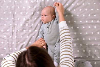 Photo of Mother and her little baby on bed, top view