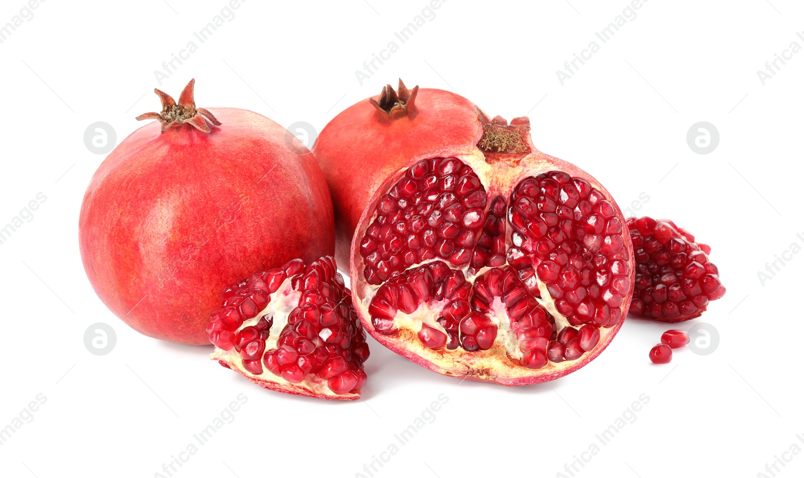 Photo of Cut and whole pomegranates isolated on white