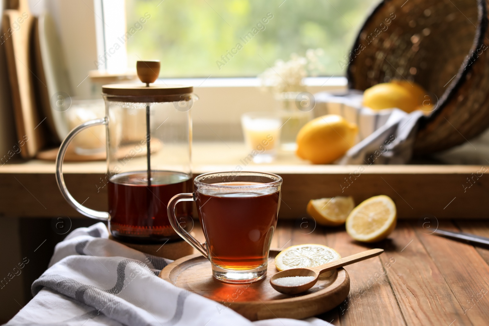 Photo of Delicious tea, sugar and lemon on wooden table, space for text