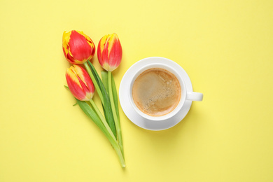 Photo of Spring tulips and coffee on yellow background, flat lay. Good morning