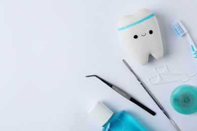 Photo of Composition with tooth and dentist tools on white background, top view. Space for text