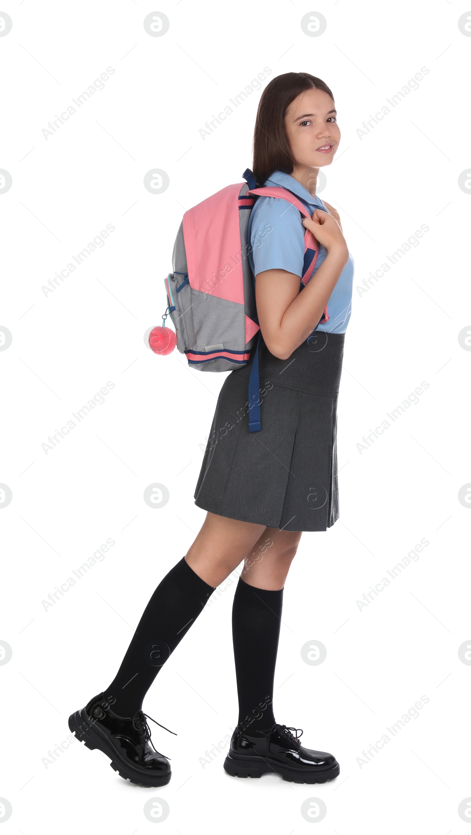 Photo of Teenage girl in school uniform with backpack on white background