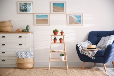 Stylish living room interior with wooden ladder and comfortable armchair