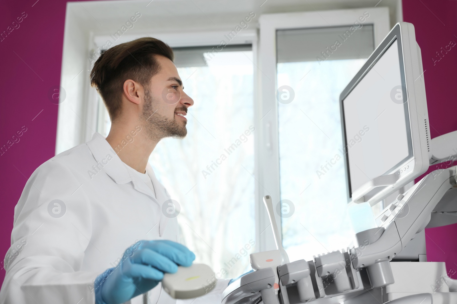 Photo of Sonographer using modern ultrasound machine in clinic