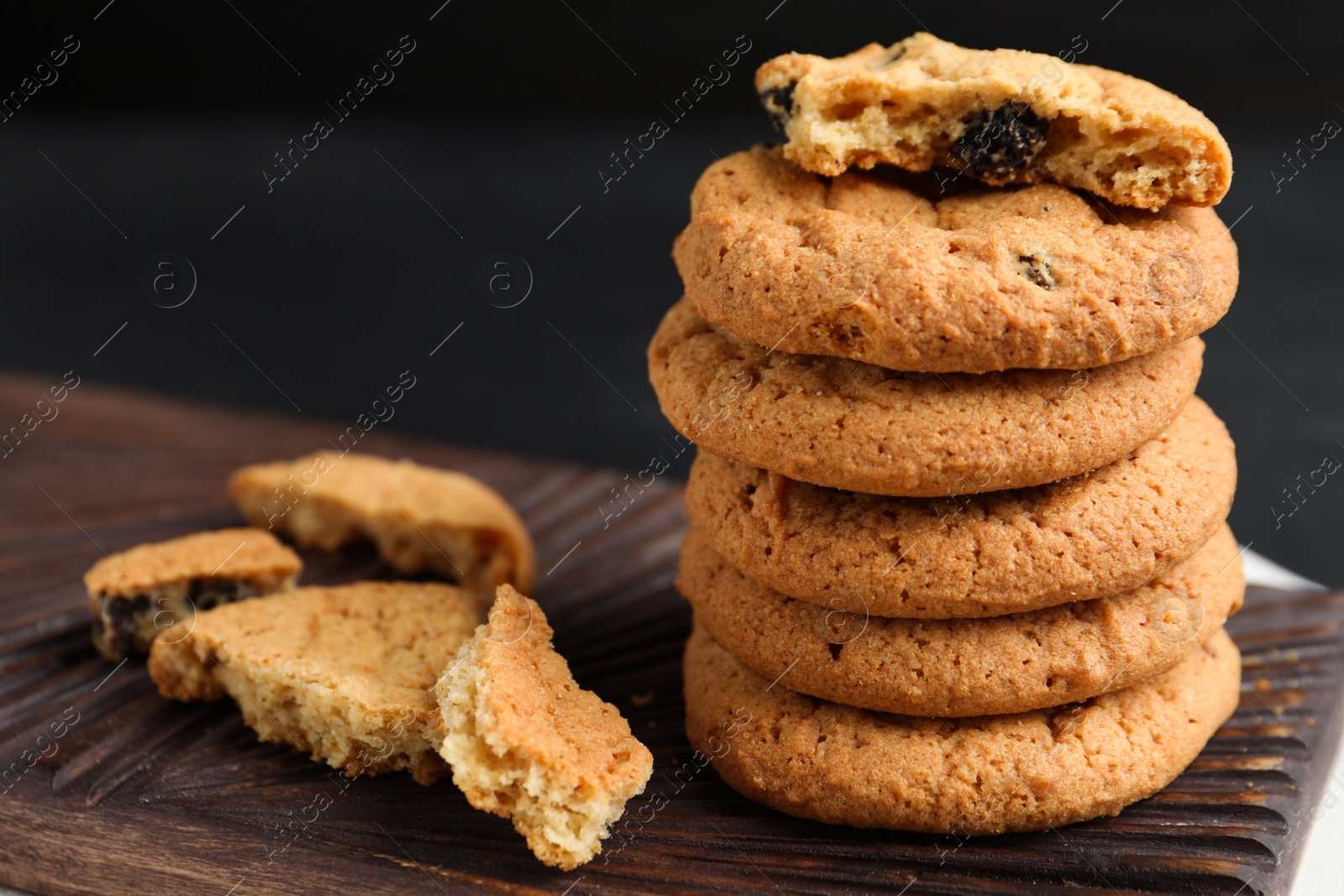 Photo of Delicious cookies with raisins on board, closeup