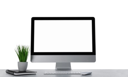 Photo of Computer, potted plant and notebook on table against white background. Stylish workplace