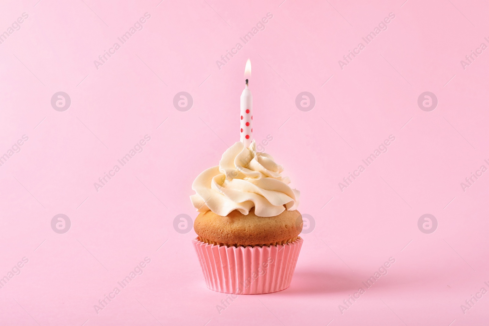 Photo of Delicious birthday cupcake with candle on color background