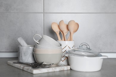 Set of cooking utensils and cookware on grey countertop