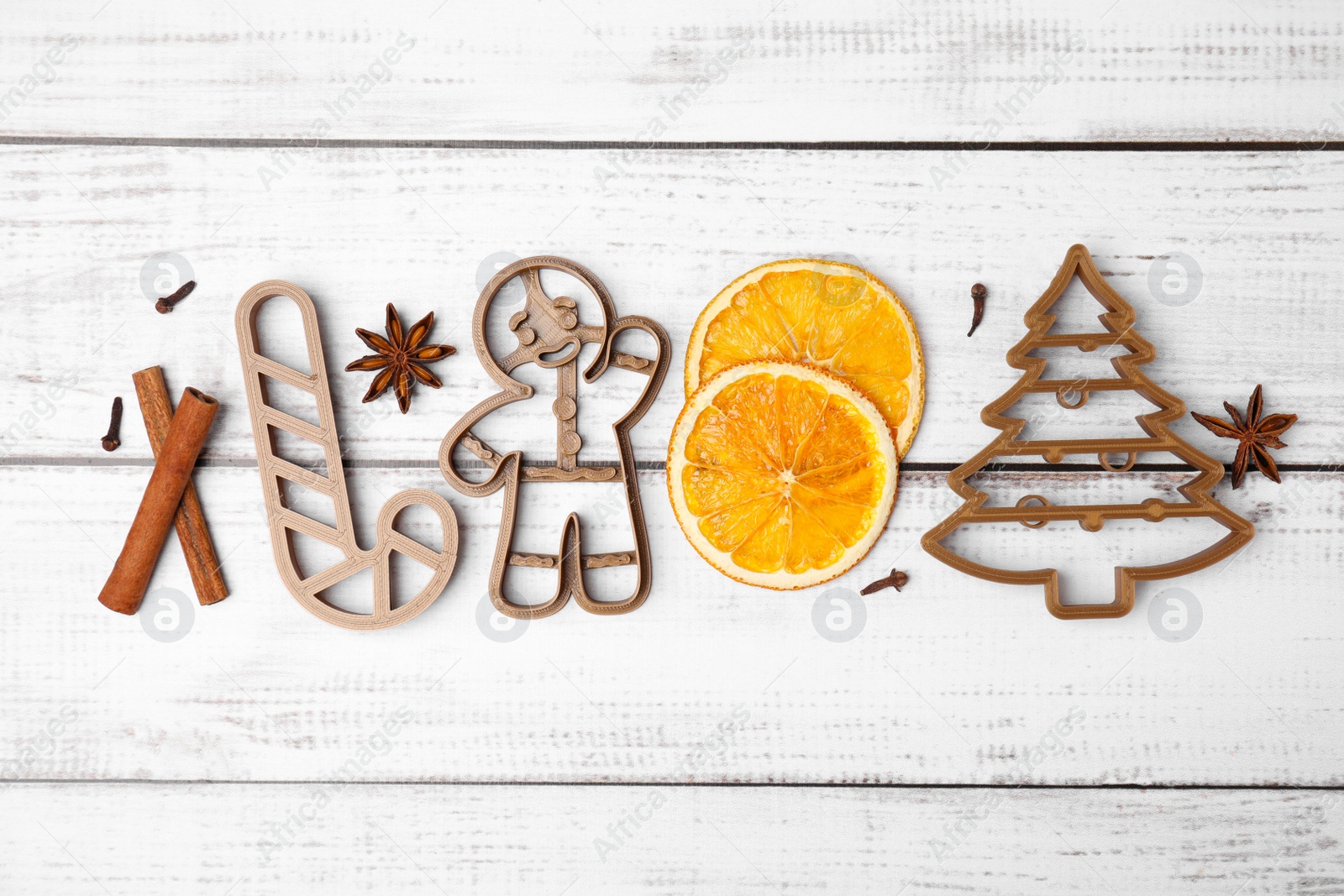 Photo of Flat lay composition with cookie cutters on white wooden table. Christmas treat