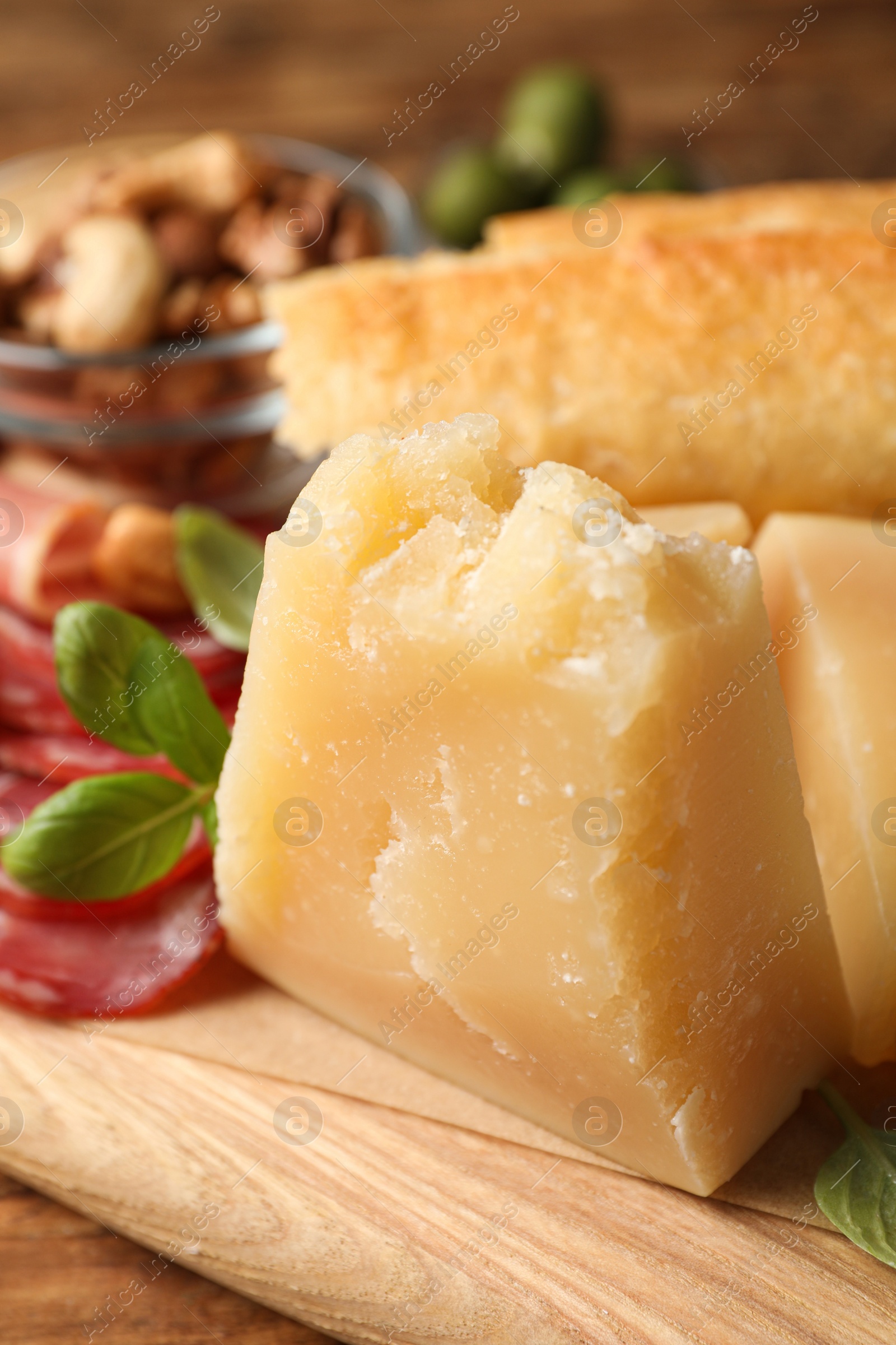 Photo of Delicious parmesan cheese on wooden board, closeup