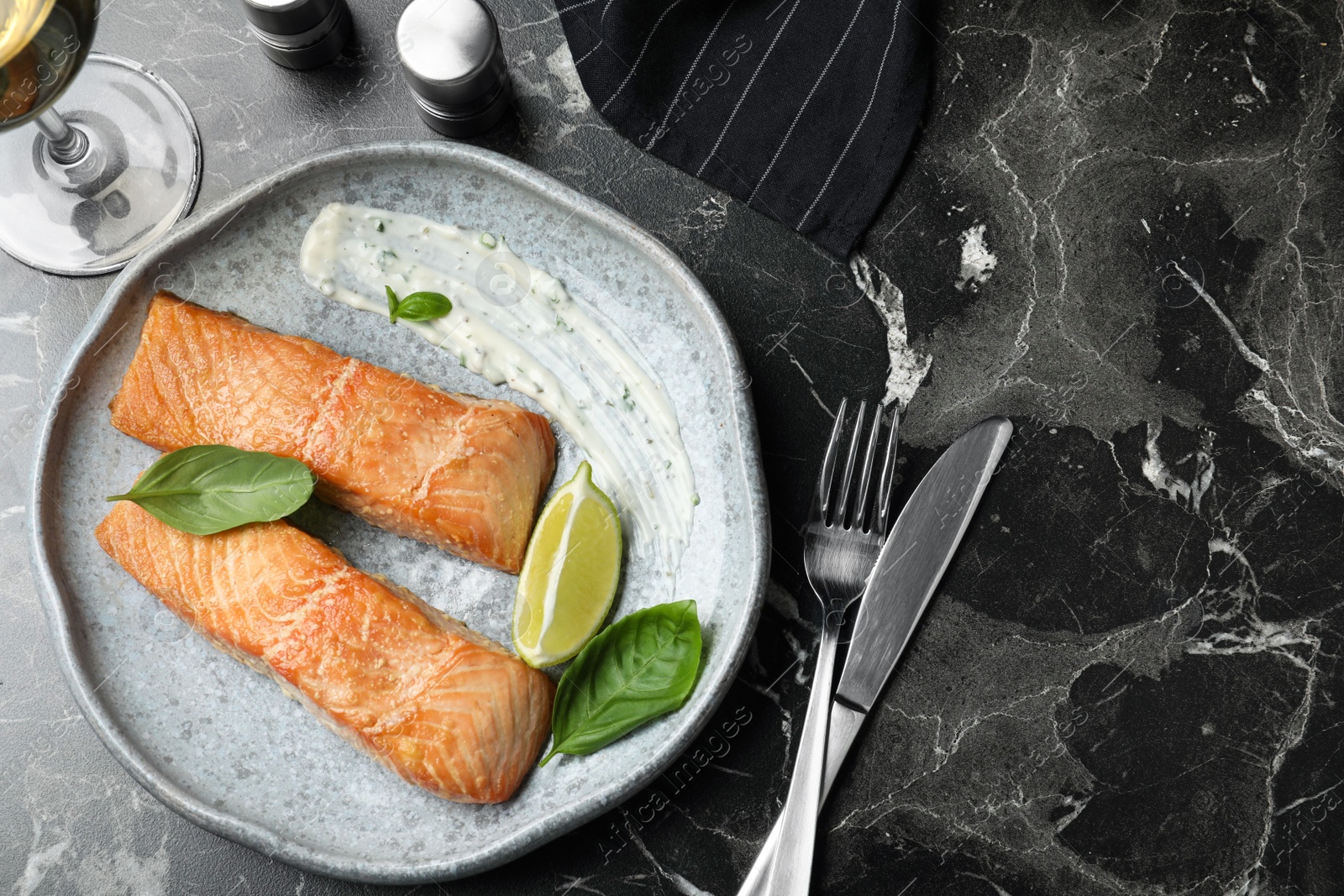 Photo of Tasty cooked red fish on dark marble table, flat lay