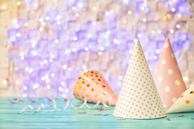 Photo of Birthday party caps on table against blurred lights