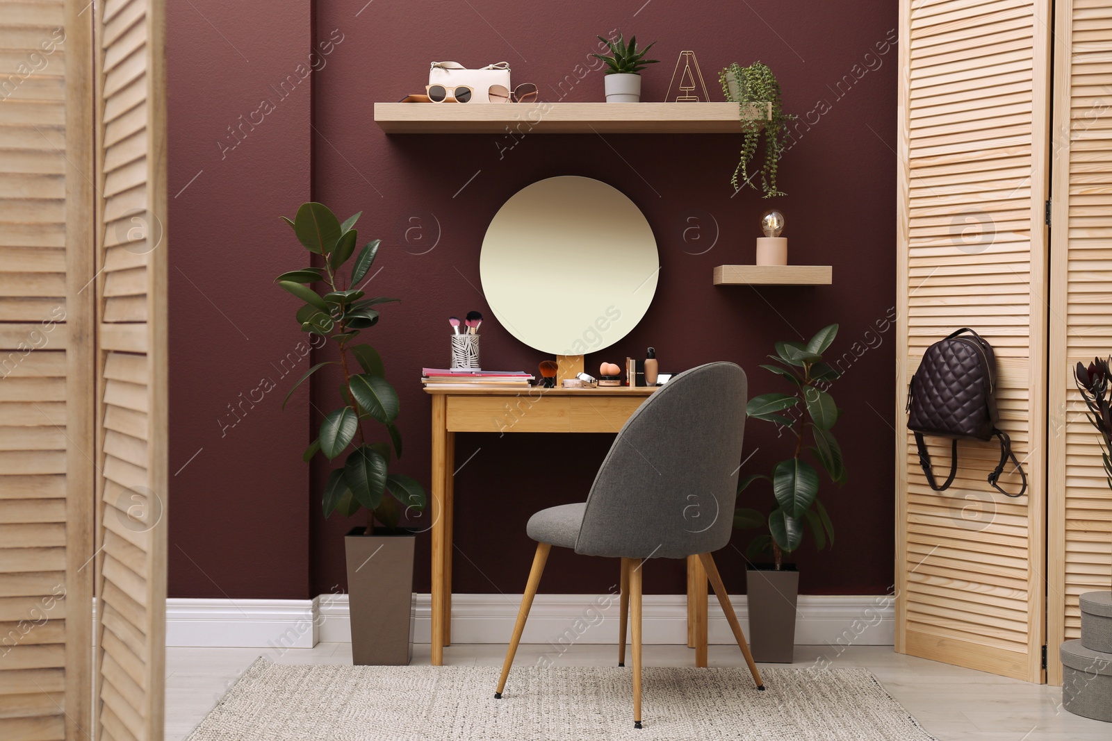 Photo of Wooden dressing table and chair near brown wall in room