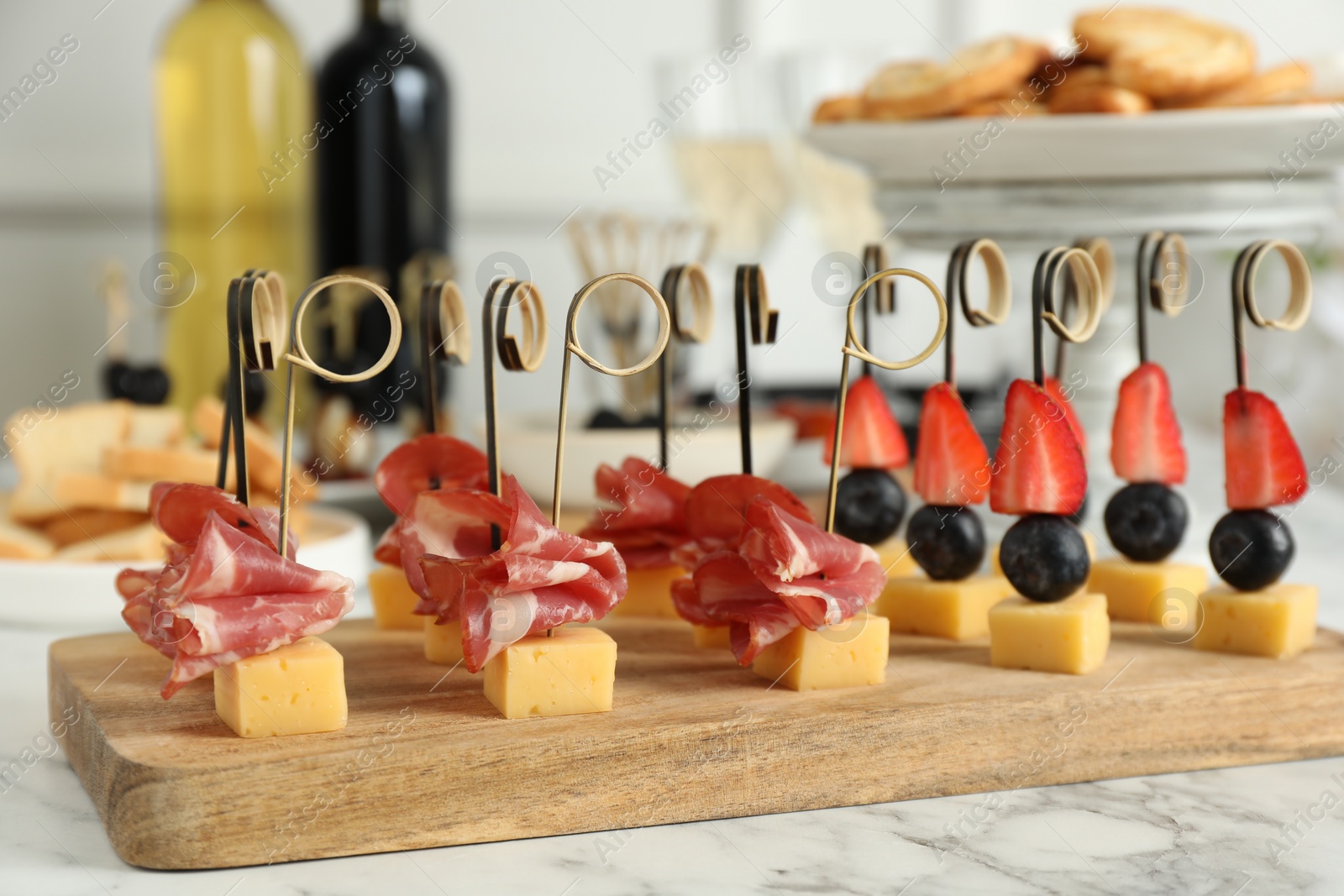 Photo of Different tasty canapes on white marble table, closeup