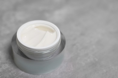 Photo of Body cream on grey table, closeup. Space for text