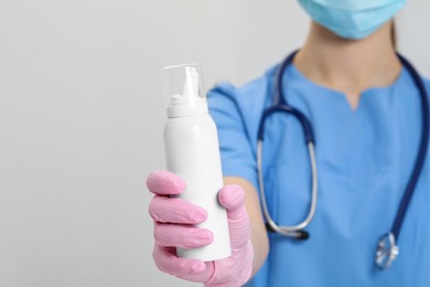 Photo of Doctor holding nasal spray on white background, closeup