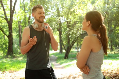 Photo of Man and woman talking before morning exercise in park