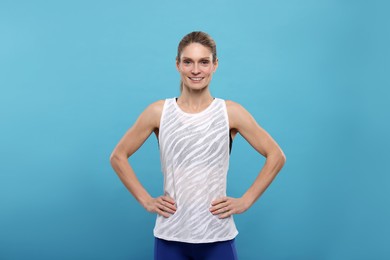 Photo of Portrait of happy sportswoman on light blue background