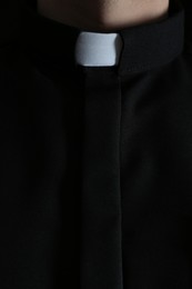 Photo of Priest wearing cassock with clerical collar, closeup view