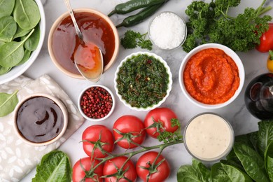 Photo of Different marinades and products on white marble table, flat lay