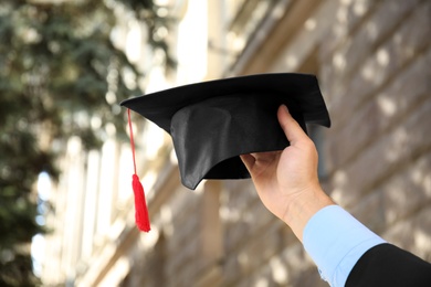 Photo of Student with graduation hat outdoors on sunny day, closeup