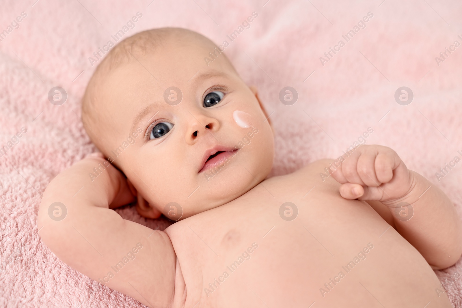 Photo of Cute little baby with cream on face on pink blanket, above view