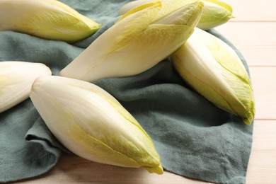 Photo of Raw ripe chicories on wooden table, closeup