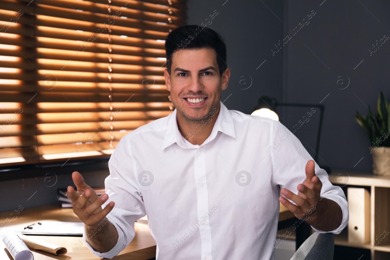 Photo of Man talking to his coworkers through video conference indoors, view from webcam