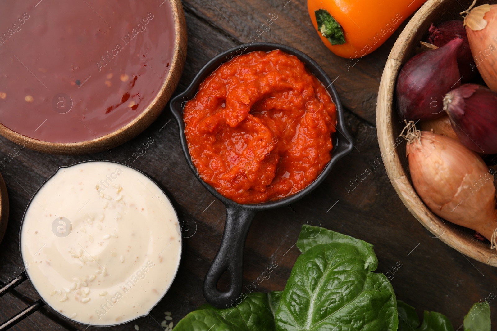 Photo of Different marinades and products on wooden table, flat lay