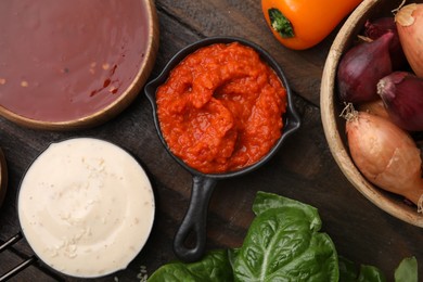 Photo of Different marinades and products on wooden table, flat lay