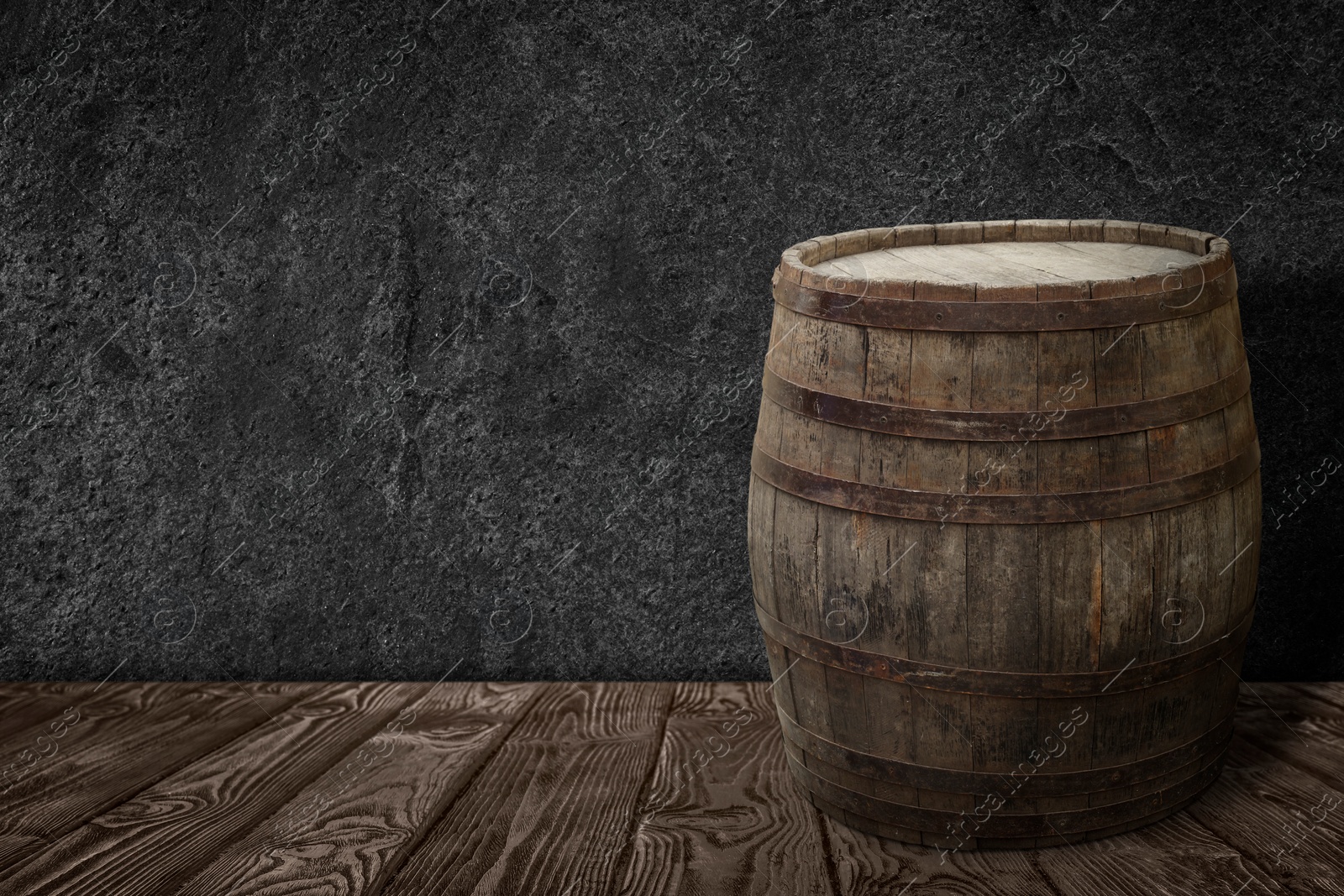 Image of One wooden barrel on surface near grey textured wall. Space for text