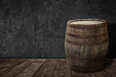 Image of One wooden barrel on surface near grey textured wall. Space for text