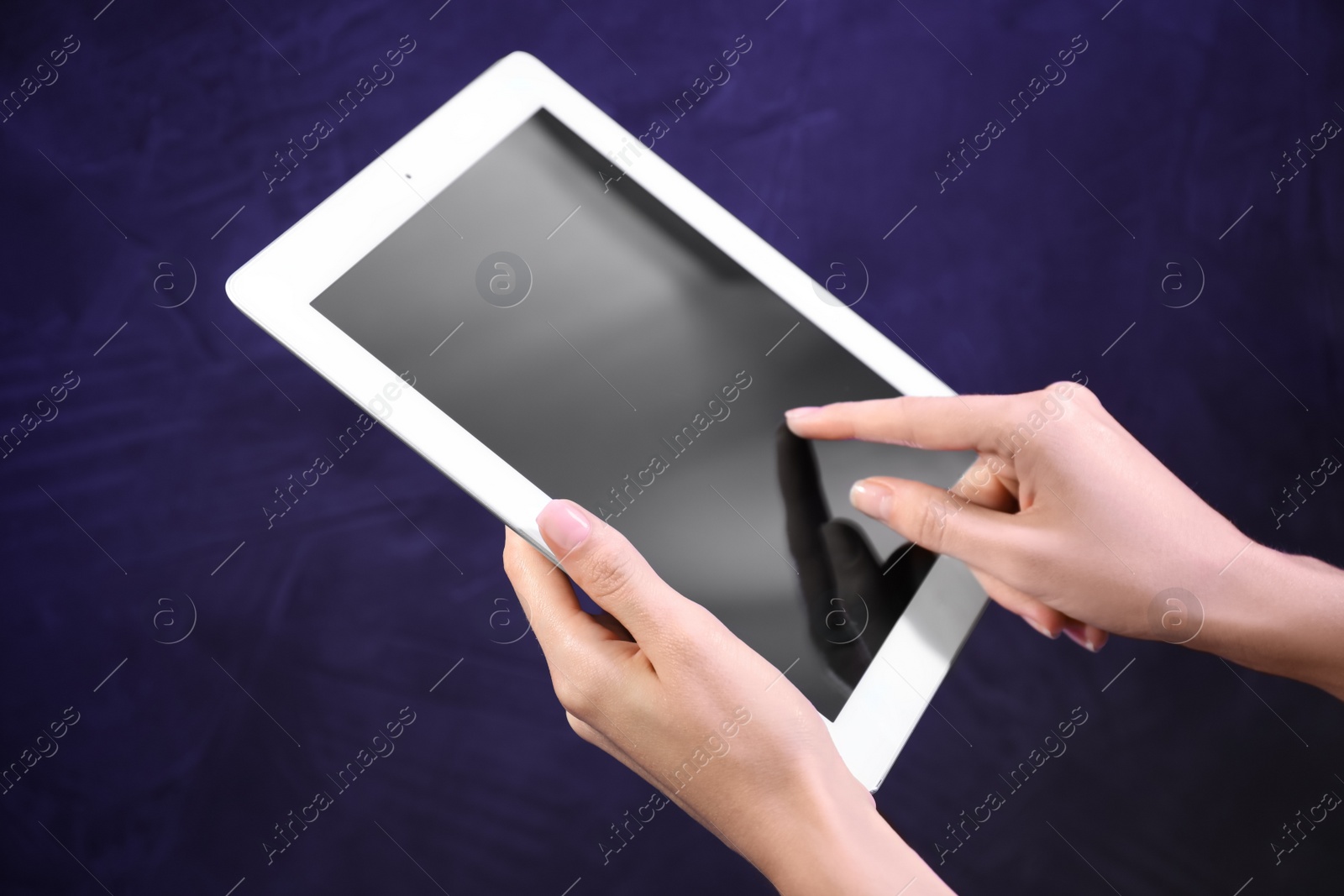 Photo of Woman using modern tablet on blue background, closeup