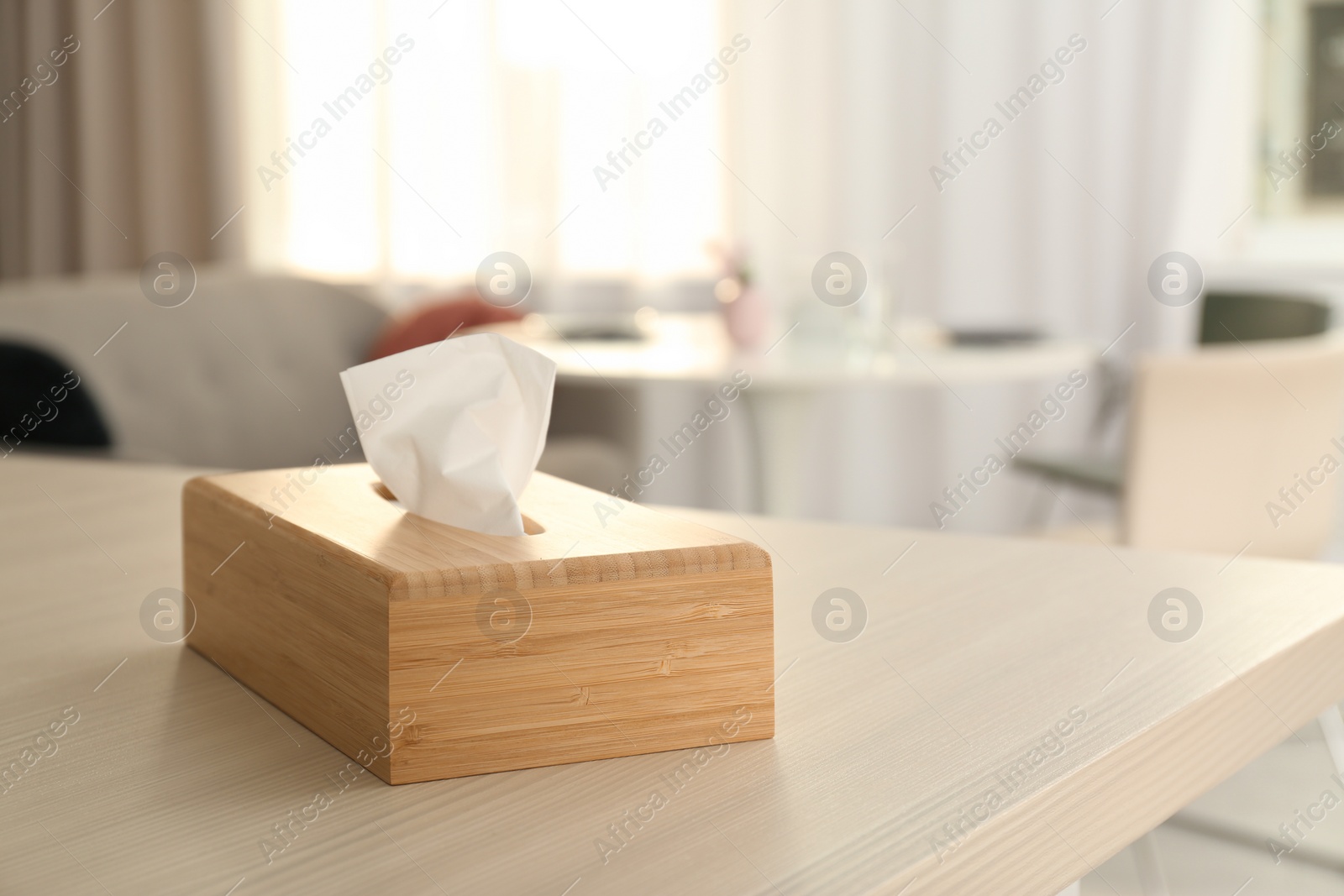 Photo of Wooden napkin holder with paper serviettes on table in room. Space for text