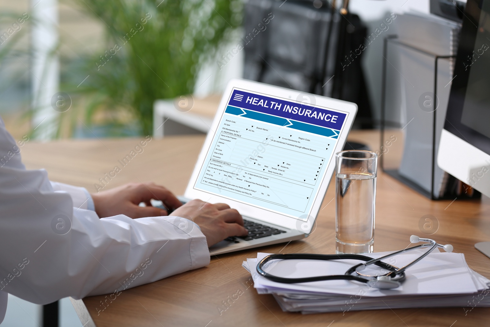 Image of Doctor with modern laptop indoors, closeup. Health insurance