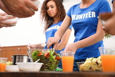 Photo of Volunteers serving food to poor people in charity centre