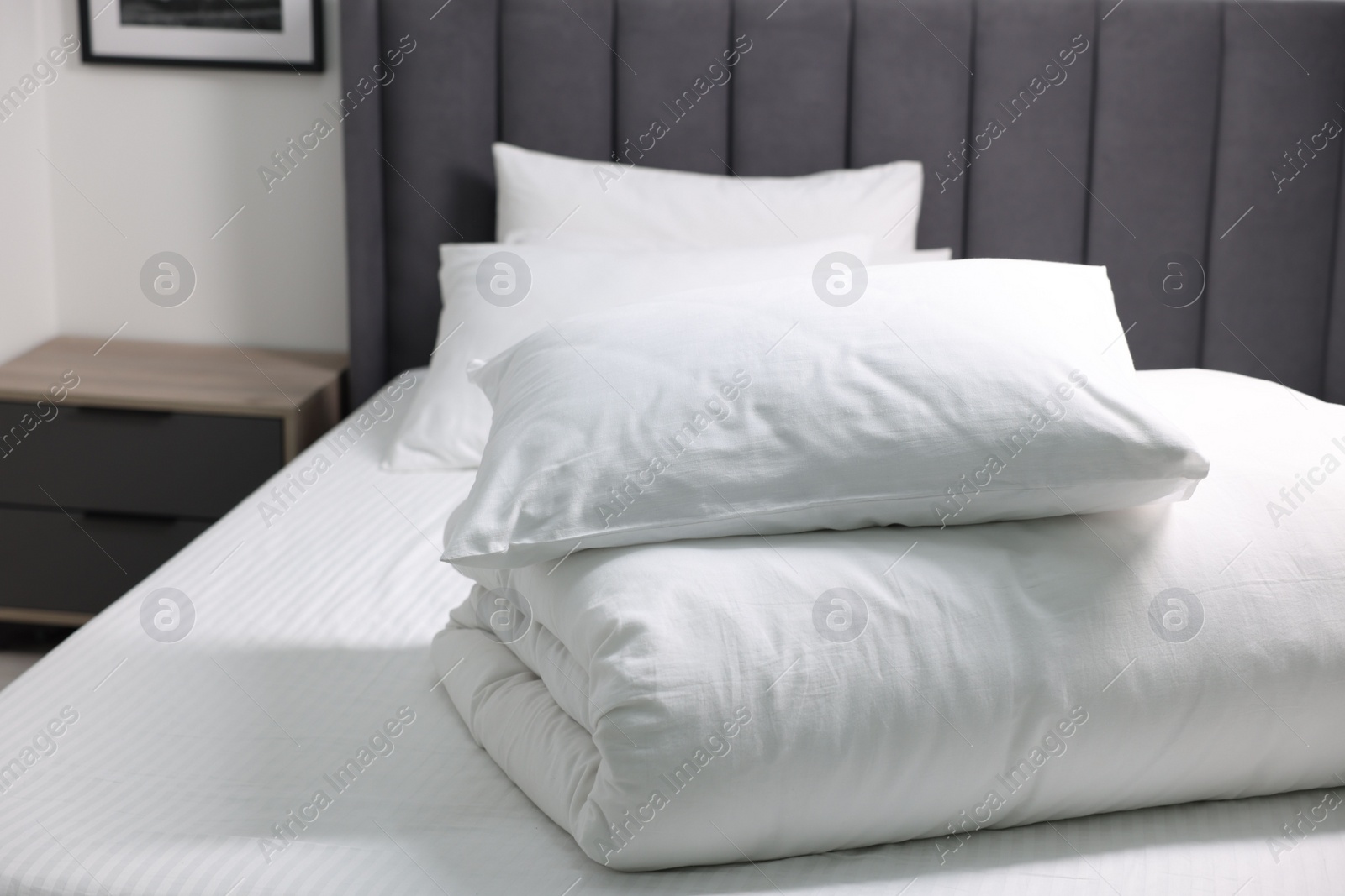 Photo of Soft white pillows and duvet on bed at home. Space for text