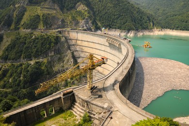 Photo of BATUMI, GEORGIA - AUGUST 13, 2022: Tower crane and hydroelectric power station in mountains