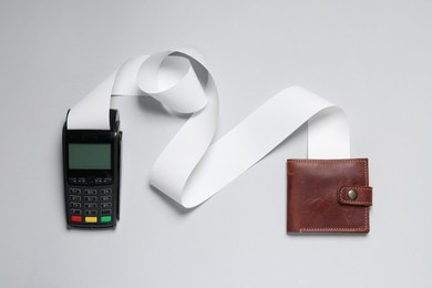 Payment terminal with thermal paper for receipt and wallet on light grey background, flat lay