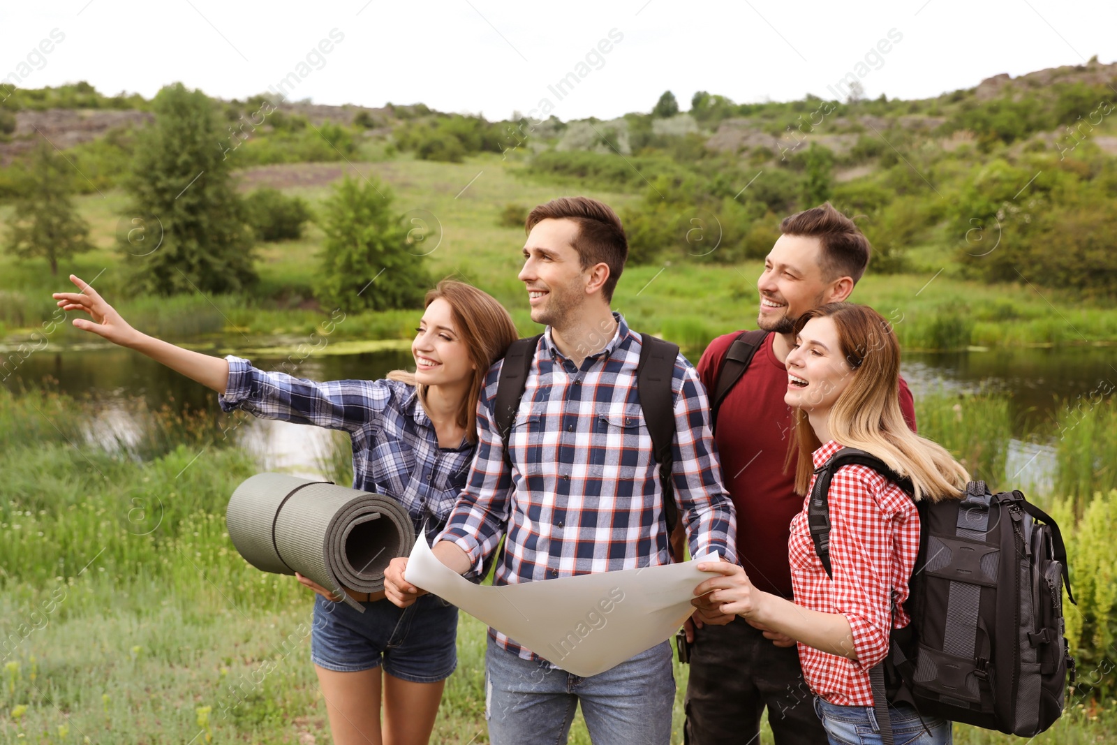 Photo of Group of young people exploring map in wilderness. Camping season