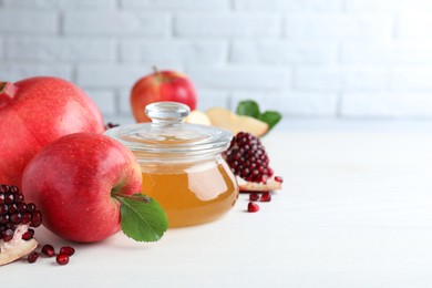 Honey, pomegranate and apples on white wooden table. Rosh Hashana holiday