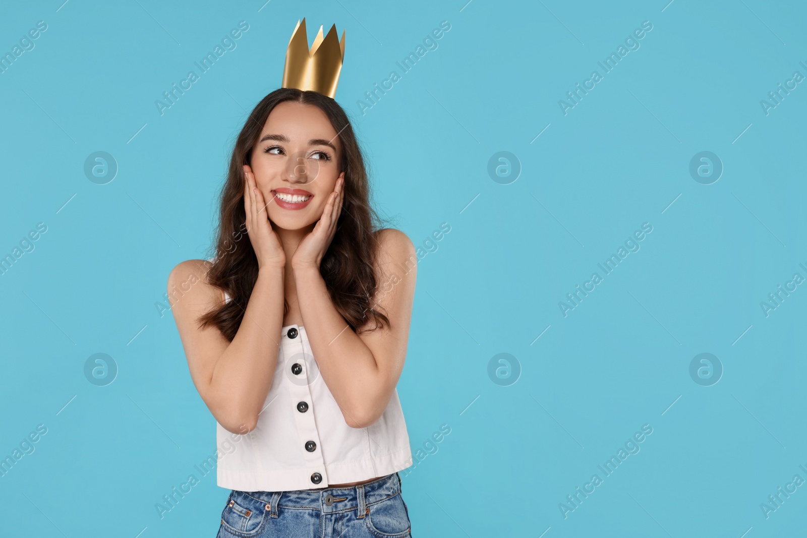 Photo of Beautiful young woman with princess crown on light blue background, space for text