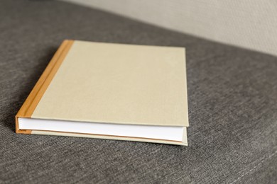 Photo of Hardcover book on grey sofa, closeup view