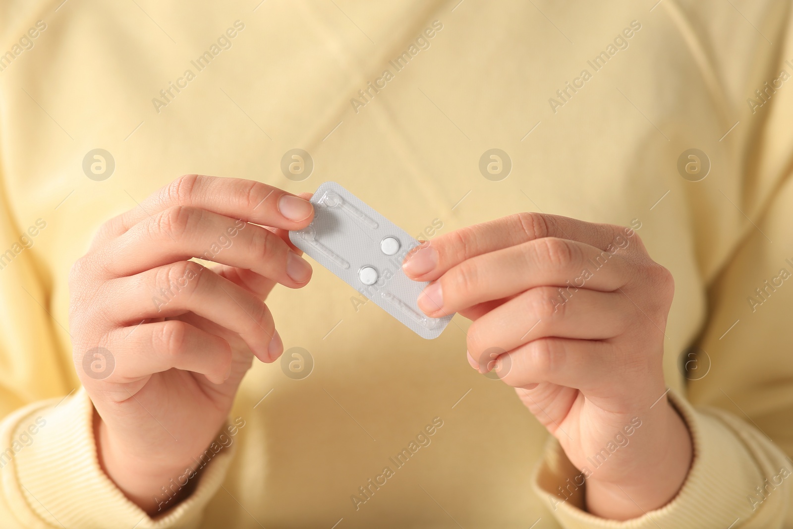 Photo of Woman holding blister of emergency contraception pills on white background, closeup