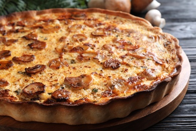 Photo of Delicious homemade mushroom pie on black wooden table, closeup