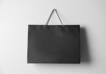 Paper shopping bag hanging on white wall