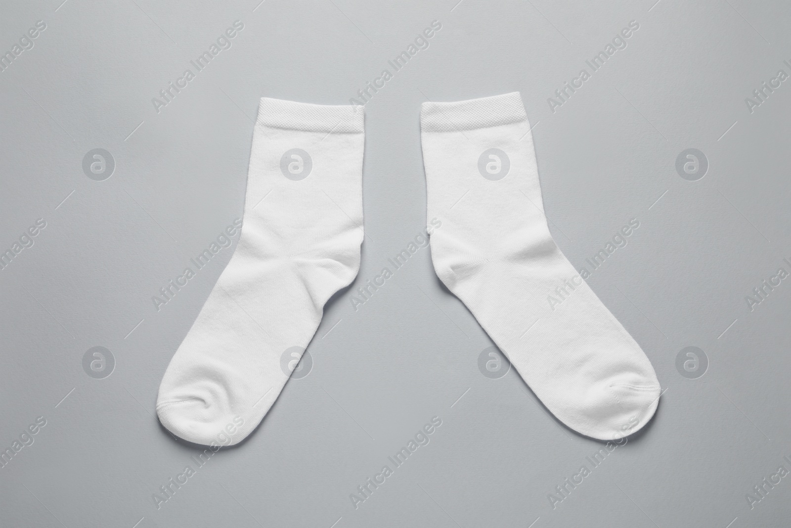 Photo of Pair of white socks on light grey background, flat lay