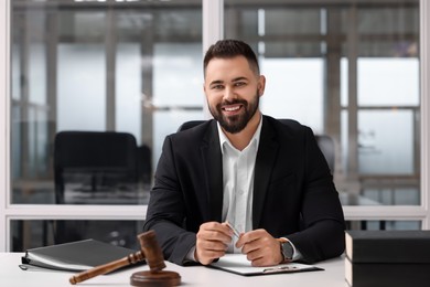 Photo of Portrait of smiling lawyer at table in office