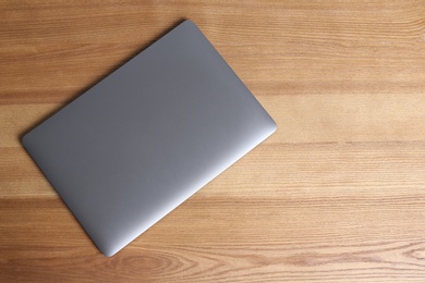 Modern laptop on wooden table, top view